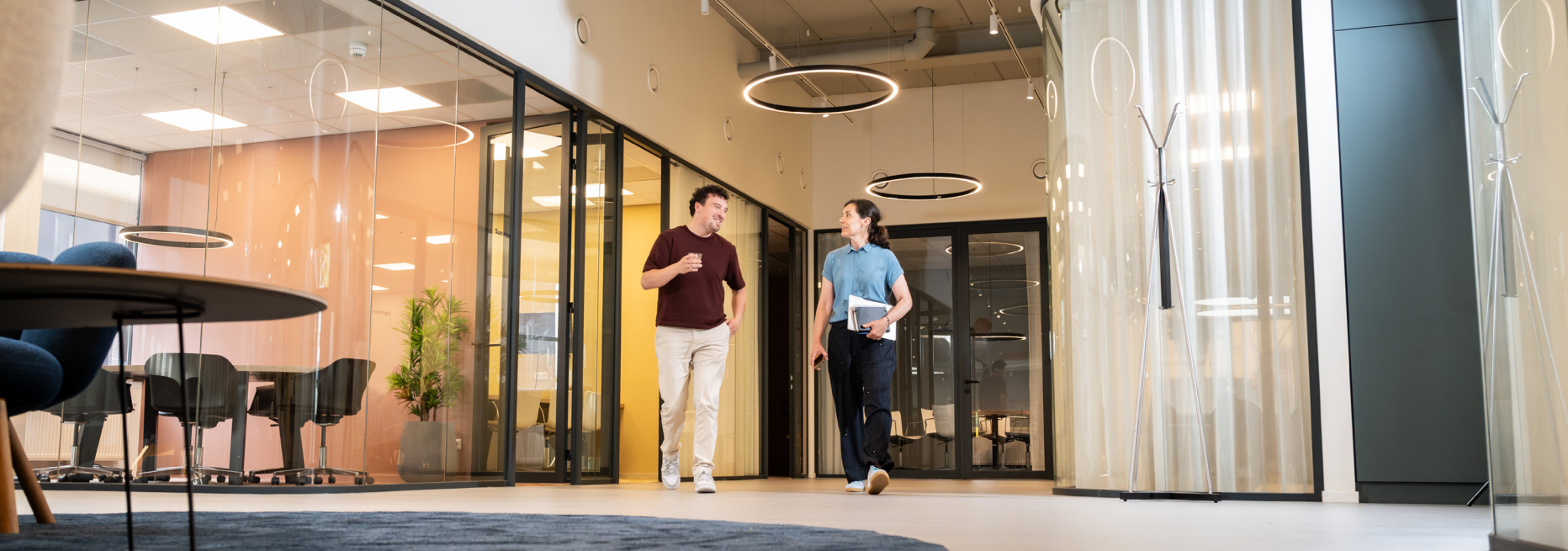 Twee mensen lopen door modern kantoor